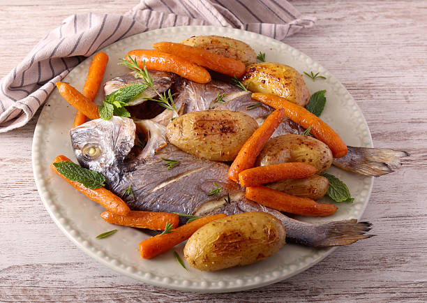 istock sea bream fish with carrot and potato 2219074460