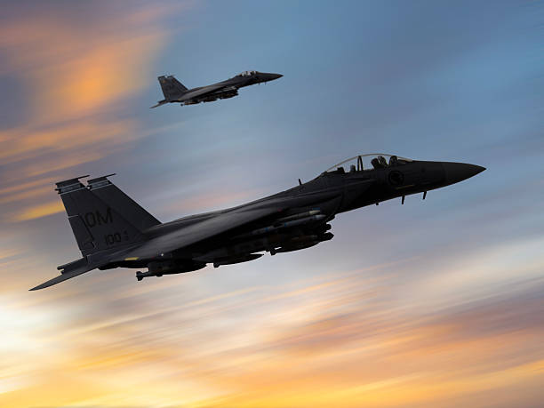 istock F-15 Fighter jets in flight over the clouds at sunset. 2219075504