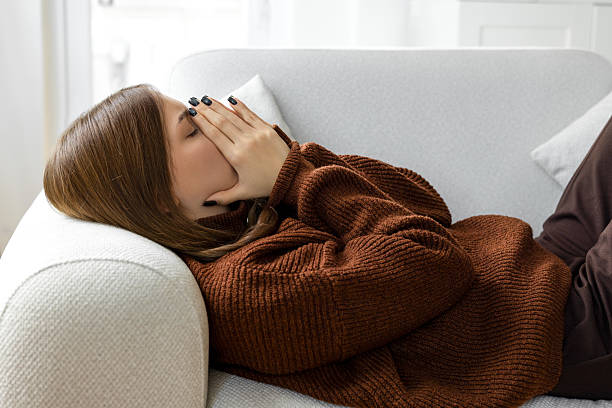 istock Depressed female lying on a couch 2219075553