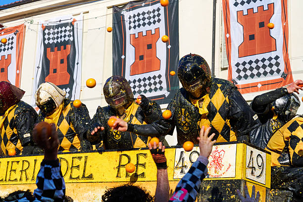 Ivrea, Italy - March 02, 2025: groups in traditional dressing take part in the Battle of the Oranges, where a teams of orange handlers on foot throw oranges (representing old weapons and stones) against aranceri of the team \