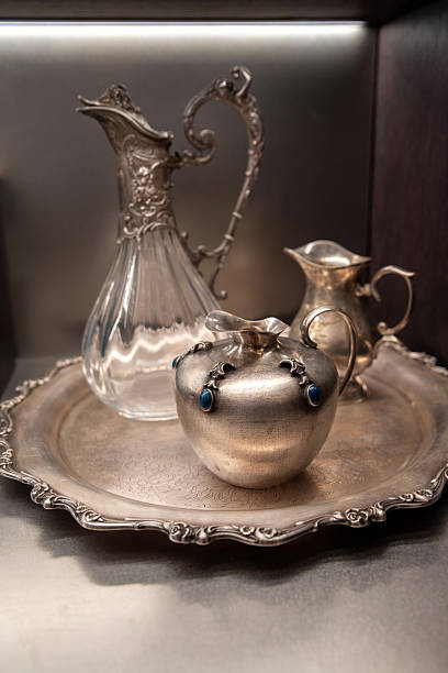 istock Vintage silver jugs and glass pitcher on ornate metal tray 2219082170