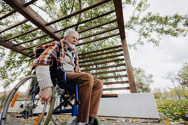 Middle-aged and elderly people are walking in the park with an elderly disabled person whose legs have lost the ability to walk.
