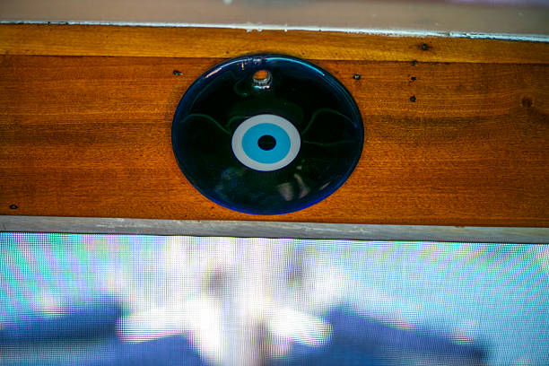 A close-up of a traditional evil eye amulet mounted on a wooden wall of a ship, symbolizing protection and good fortune against the backdrop of a seafaring journey.