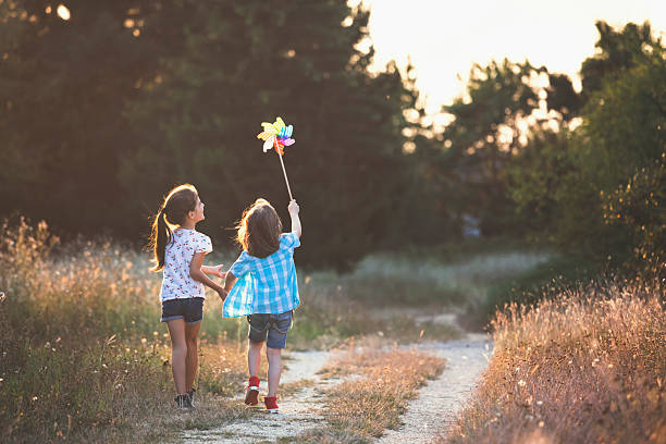 istock Kids running with pinwheel toy at sunset 2219092404
