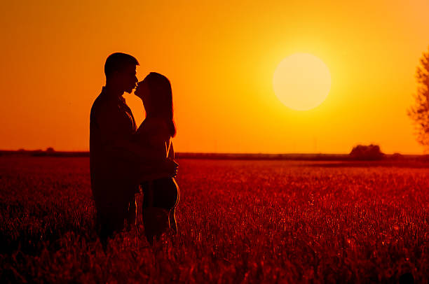 Young happy couple relaxing in the summer nature at sunset.