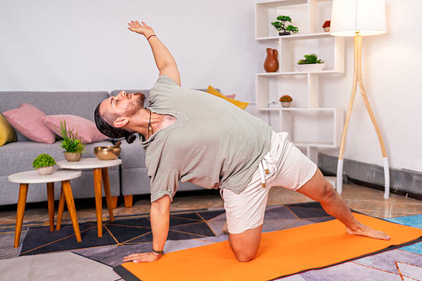 istock Young man practicing yoga at home for peace of mind 2219108302