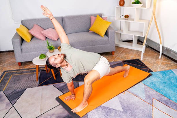 istock Young man practicing yoga at home for peace of mind 2219108337