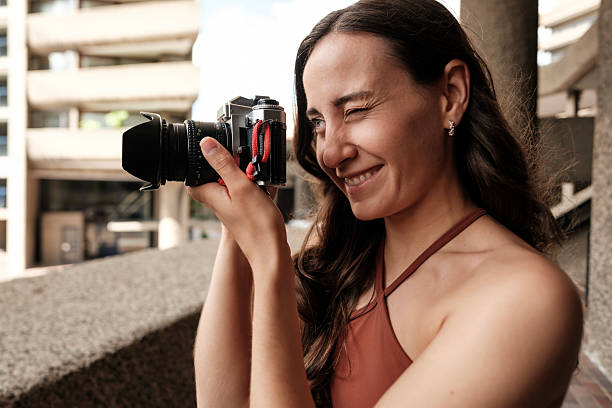 istock Photographer winking and smiling while taking photos with analog camera 2219111285