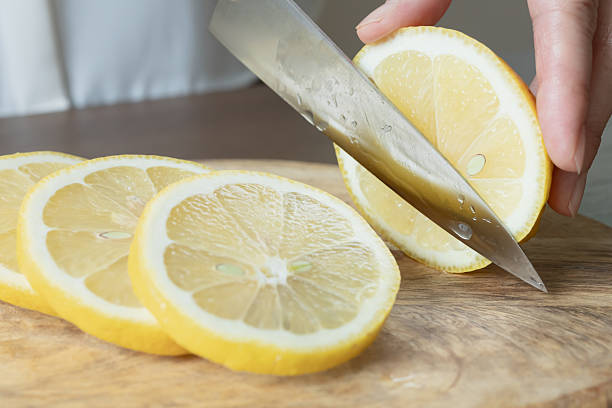 istock Lemon slices. Cut the lemon with a knife. 2219113929