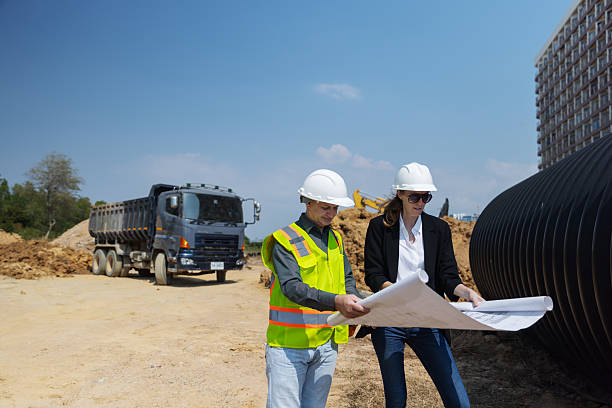 istock Two construction professionals discuss architectural blueprints at a building site 2219116850