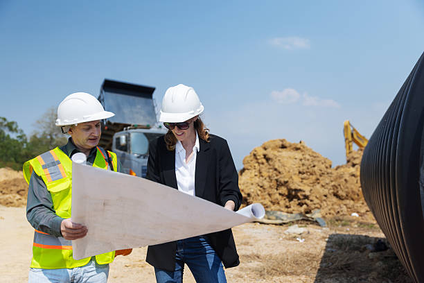 istock Two construction professionals discuss architectural blueprints at a building site 2219116868