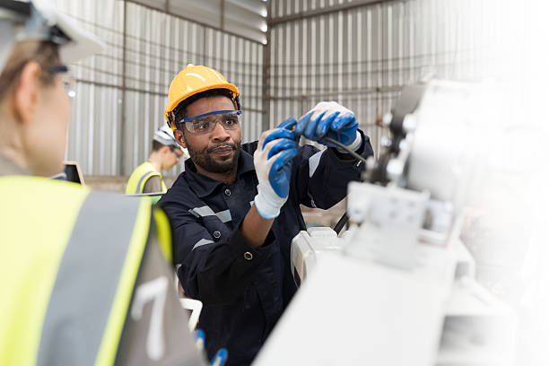 istock Robotic arm, Automatic robotic arm welding. Robotic manufacturing industry. Team of engineers setup, install, maintain, repair mechanism of operation of robotic arm in storage warehouse 2219116903