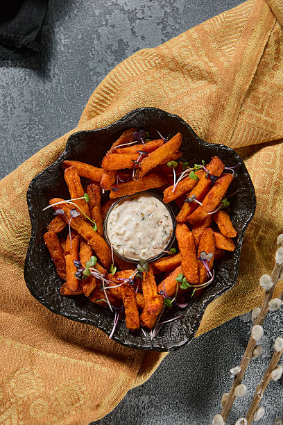 istock Crispy sweet potato fries with creamy dip, moody lighting, rustic composition 2219117671