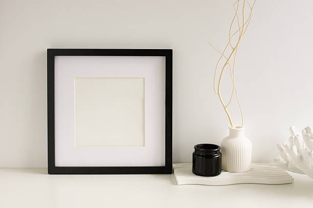 istock Photo frame mockup and modern home table decor white and black colors on white wall background . 2219118942