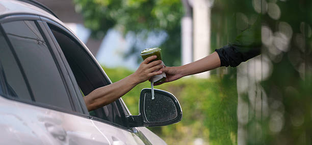 istock Customers receive coffee cups from drive-thru counter staff during rush hour. 2219119822
