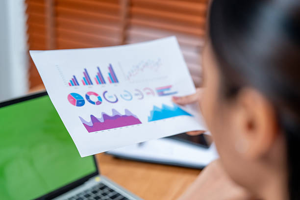 Analyzing cosmetic marketing data requires careful planning and effective packaging to convey insights clearly. This captures focused individual reviewing charts and graphs paper, emphasizing