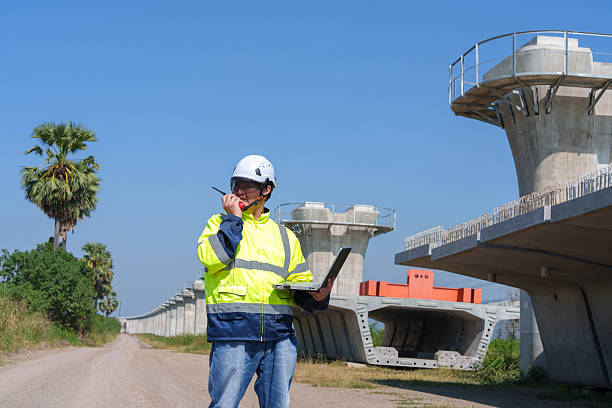 istock Asian architect engineer wearing safety uniform surveying and working at building structure checking blueprints construction site road general job details business concept architecture street 2219120617