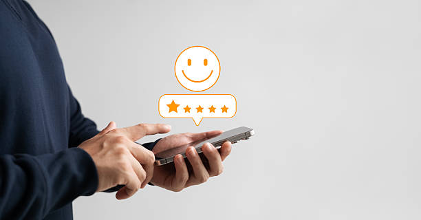 istock Customer giving 5-star rating on smartphone with smiley icon, representing user feedback, satisfaction review, mobile experience, and positive digital service evaluation. 2219121181