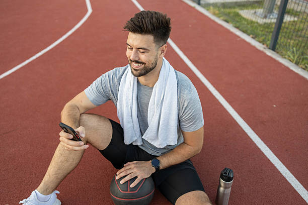 istock Smiling Player Engaged With Mobile Phone 2219132780