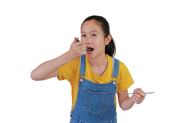 istock Asian girl holding fork and spoon with eating posture isolated on white studio background. Ready for a meal. 2219135562