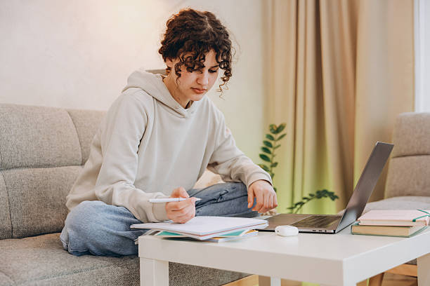 istock Teenage student girl doing homework using laptop at home 2219141493