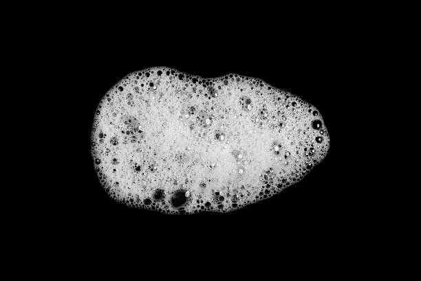 Abstract soap bubbles, shampoo or shaving cream. Isolated soap bubbles on black background with texture and contrast background.