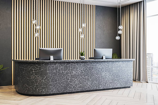 istock Modern luxury office reception interior with stone counter, wooden panel wall, and city view through large window in bright daylight. 3D Rendering 2219143317