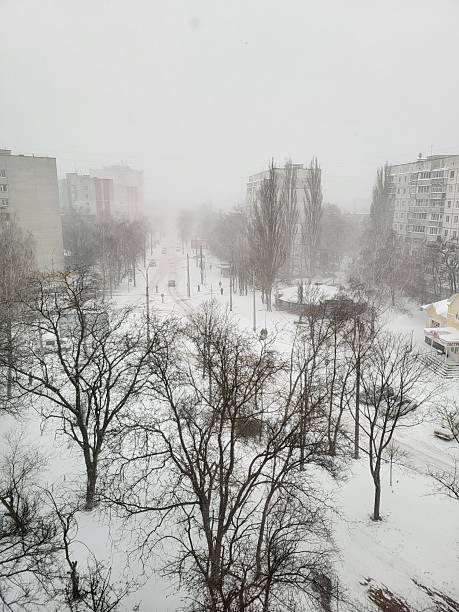 istock Snowfall over residential street with apartment blocks 2219144035
