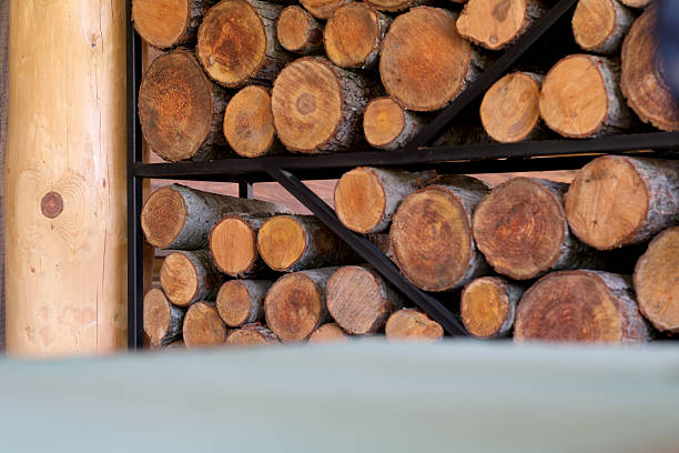 Stacks of warm, textured logs bring a rustic charm to the serene cabin interior.