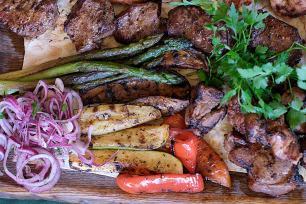 istock Grilled feast with succulent meats and vibrant vegetables at sunset 2219144149