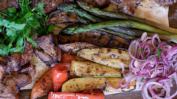 istock Delicious grilled meats and vegetables on a rustic wooden platter 2219144150