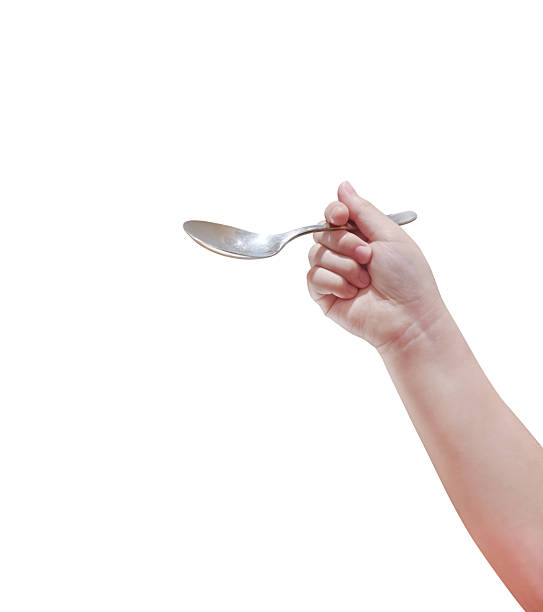 istock Spoon in child's hand, isolated on white background. 2219144639