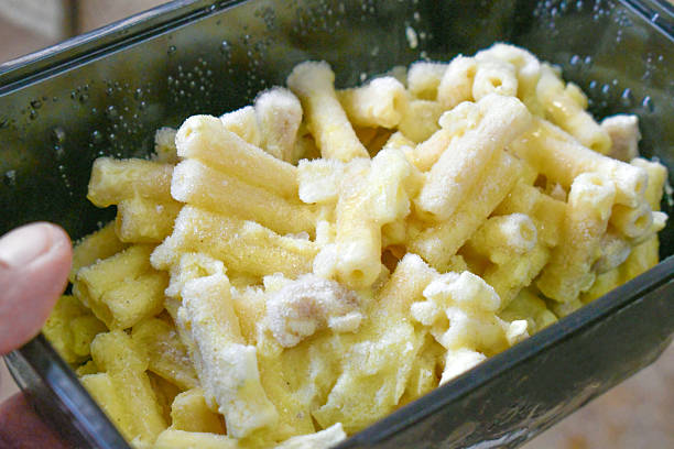 Frozen creamy pasta with pork in plastic box container.