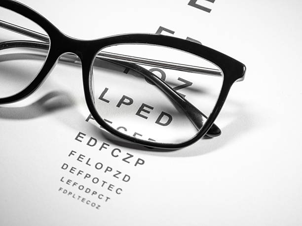 istock Corrective glasses lie on the Snellen vision chart 2219146315
