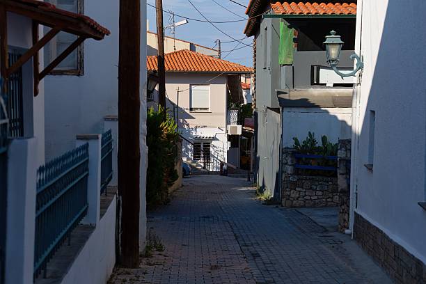 istock A narrow street winds between buildings in a sunlit scene. 2219150182