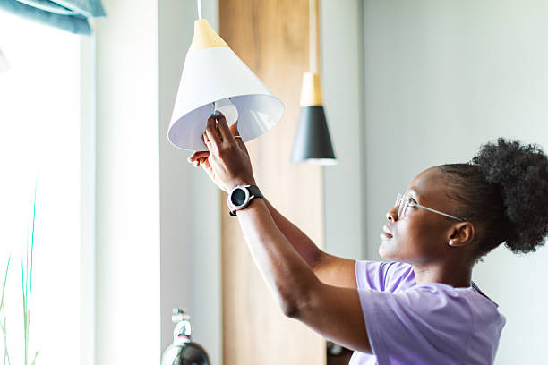 Young adult woman changing burnt lamp