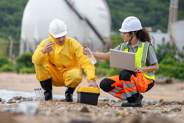 istock Environmental Engineers Conducting Field Work for Pollution Control, Workers Collecting Water Samples for Environmental Research, Engineers Analyzing Environmental Data on a Beach Cleanup Project 2219151731