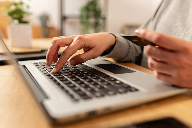 istock Close up view of young woman using laptop computer and credit card to do online shopping 2219153473