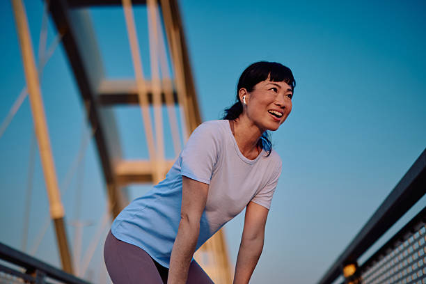 istock Asian woman taking a break during her outdoor workout routine 2219154923