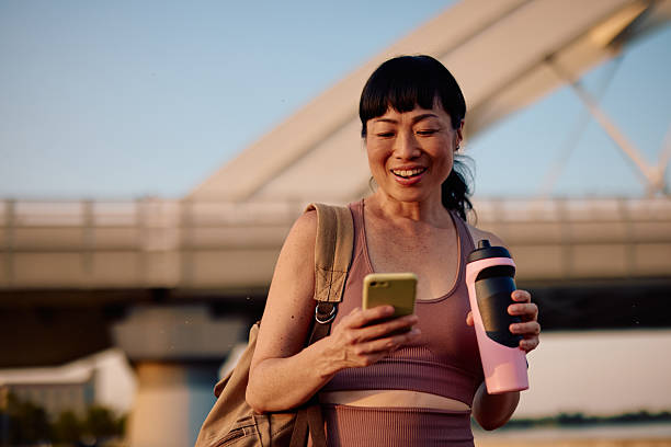 Smiling sportswoman checking her smartphone after training