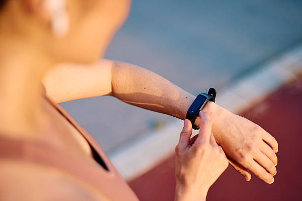 istock Woman checking fitness tracker during running training at sunset 2219155002
