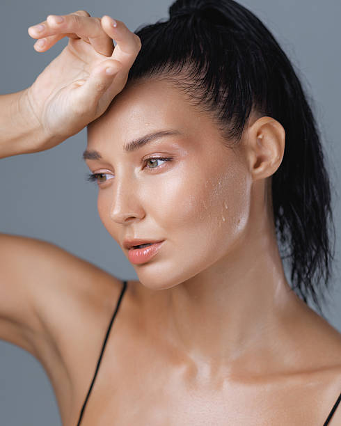 istock Exhausted Woman with Dewy Skin Resting Hand on Forehead After Workout 2219156290