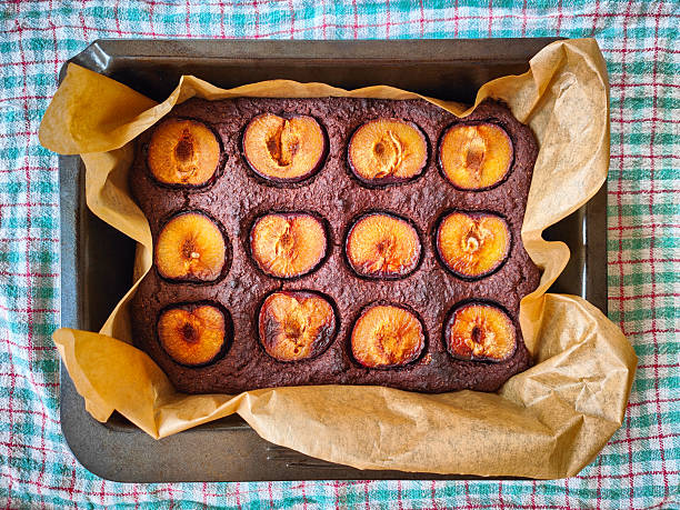 Homemade plum cake on a baking sheet in a metal pan