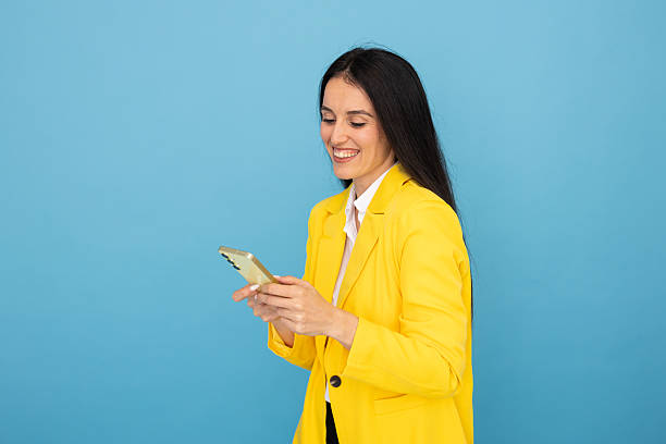 istock Cheerful businesswoman using mobile phone app, typing a message, browsing internet, ordering online, shopping, playing a game, checking social media 2219157415