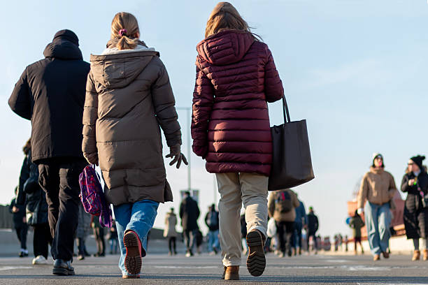 Belgrade, Serbia, 09. February - Walking through the streets of the city on a sunny autumn day. People walking in the street front and back view.