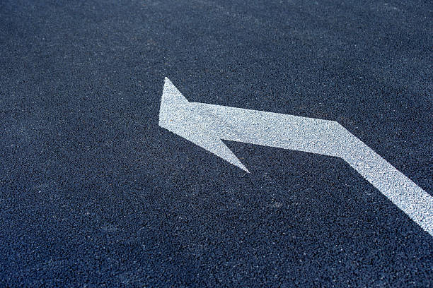 Turn left symbol on asphalt road.