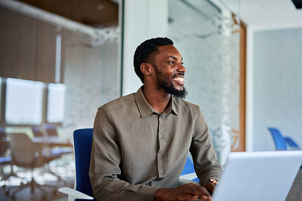 istock Young businessman smiling and working on laptop in modern office 2219159797