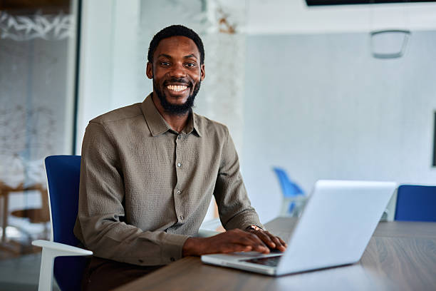 istock Smiling young businessman working on laptop in modern office 2219159806