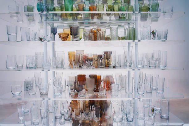 Vintage drinking glasses clear and colored on display with a white backgroun in new york.