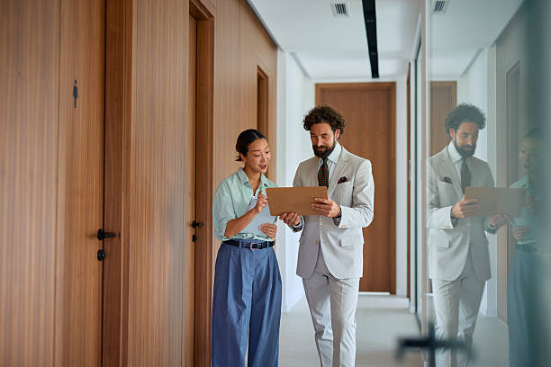 istock Businesspeople walking and discussing in office hallway 2219160200